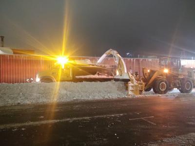 Dump truck and tractor removing snow from streets