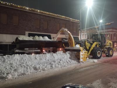 Dump truck and tractor removing snow from streets